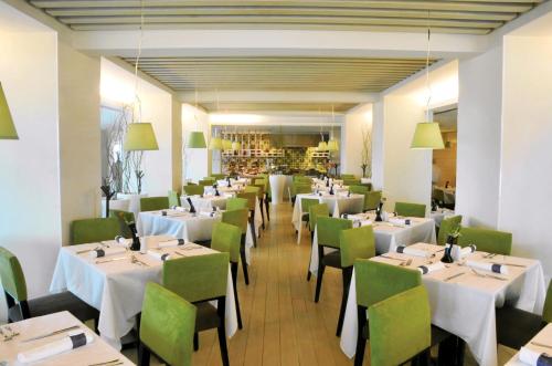 a dining room with white tables and green chairs at Emporio Veracruz in Veracruz