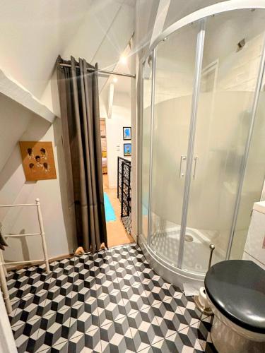 La salle de bains est pourvue d'une douche et d'un sol en damier noir et blanc. dans l'établissement Ciel et Mer, à Varengeville-sur-Mer