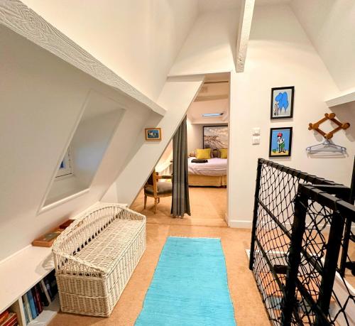 - un salon avec un escalier doté d'un tapis bleu dans l'établissement Ciel et Mer, à Varengeville-sur-Mer