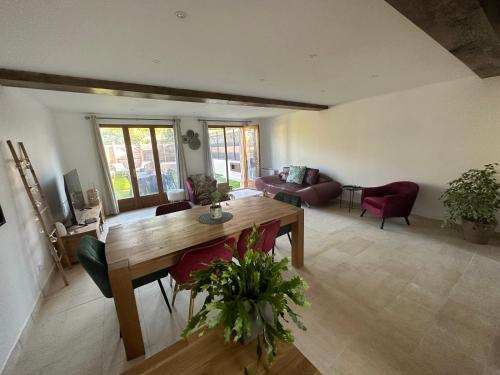 a living room with a wooden table and chairs at Jolie maison style champenois Classement 3 étoiles Gîtes de France in Barberey-Saint-Sulpice