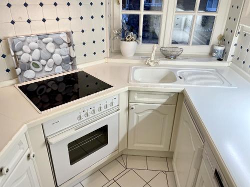 a white kitchen with a sink and a stove at Sunny-Beach in Kampen