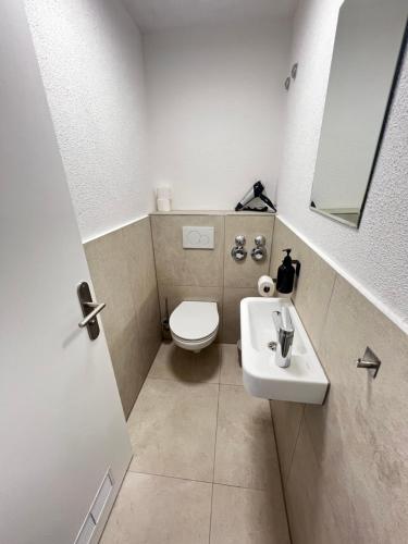 ein kleines Bad mit WC und Waschbecken in der Unterkunft KEEP Hosting L24 Apartment 