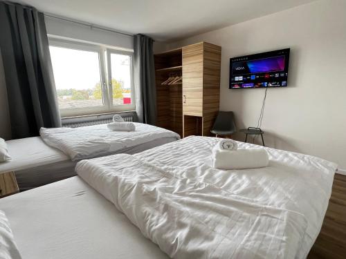 um quarto com 2 camas e uma televisão de ecrã plano em KEEP Hosting L24 Apartment 