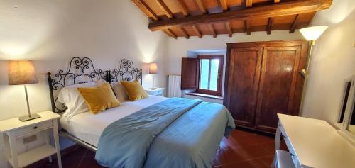 een slaapkamer met een groot bed met gele kussens bij La Volpaia 1521 in Barberino di Val dʼElsa