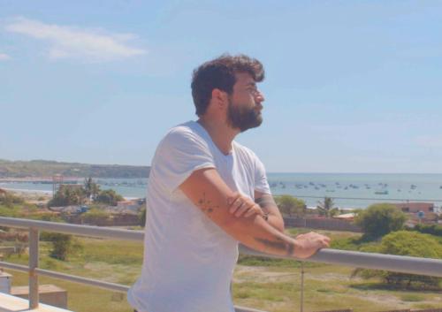 ロス・オルガノスにあるCasa Norte North Beachの海を見渡すバルコニーに立つ男