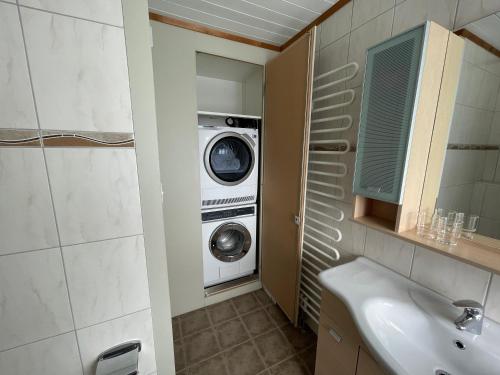 a bathroom with a washing machine and a washer and dryer at Stockberghüsli in Nesslau