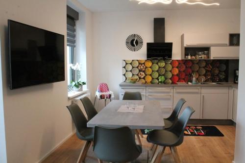 une salle à manger avec une table et des chaises ainsi qu'une cuisine dans l'établissement Ferienwohnung Schöneck, à Schöneck