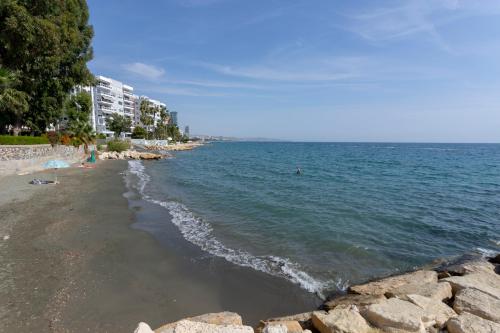 een strand met mensen die in het water zwemmen bij Kyma Beach Apt by TrulyCyprus in Limassol