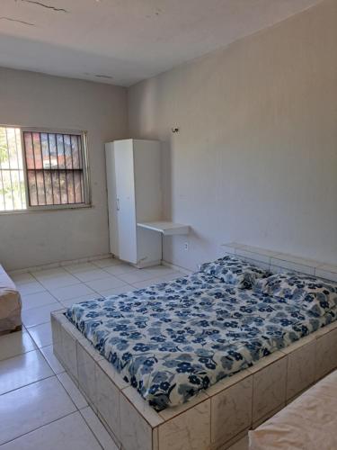 um quarto com uma cama e um frigorífico em Pousada leblon em Caucaia