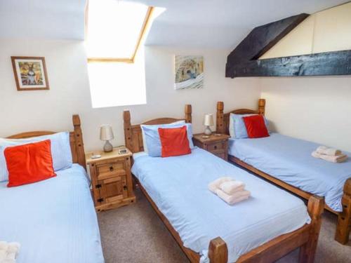 GrizebeckにあるBank End Barnのベッド3台(青と赤の枕付)が備わる客室です。