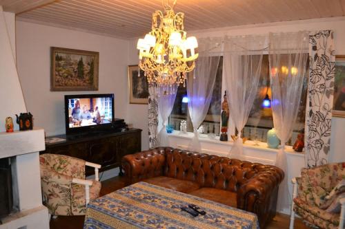 a living room with a couch and a chandelier at Havsnära Motorbåt 12 Cyklar 18+Beds VedBastu Hav! in Djurhamn
