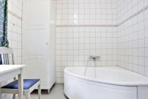 Baño blanco con bañera y lavamanos en Havsnära Motorbåt 12 Cyklar 18+Beds VedBastu Hav! en Djurhamn