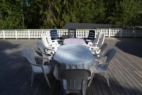 a table with white chairs and a table with a blue top at Havsnära Motorbåt 12 Cyklar 18+Beds VedBastu Hav! in Djurhamn