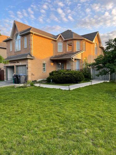 a large house with a lawn in front of it at Sweet Home with beautiful ambiance 2 bedroom in Brampton