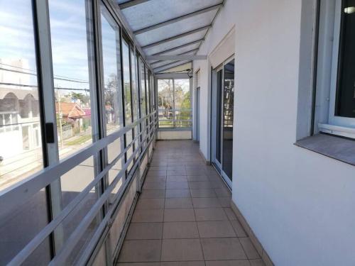 un couloir vide d'un immeuble avec des fenêtres dans l'établissement Departamento de temporada para 6 personas, à Mar de Ajó