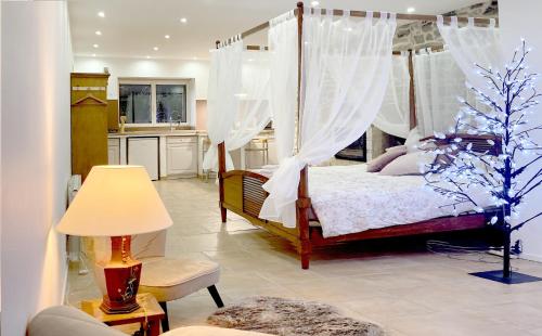 1 dormitorio con cama con dosel y cocina en Domaine de la Tranquillité V, en Noyal-Muzillac