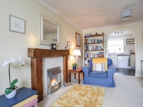 a living room with a blue chair and a fireplace at Wingelock in Rhosneigr