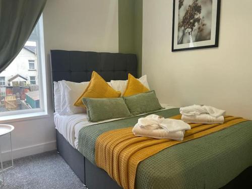 a bedroom with a bed with towels on it at Pentrebach House by M-GroupSA in Troed-y-rhiw