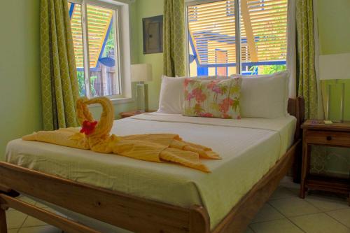 a bedroom with a bed with a swan on it at Casa Palma Placencia in Placencia Village