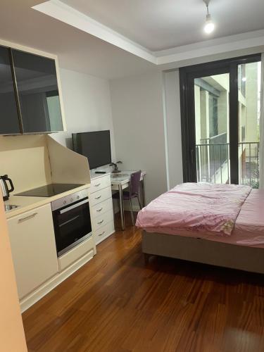 een slaapkamer met een bed, een keuken en een bureau bij Studio Flat-One Room in lux residence near Taksim-Beyoglu in Istanbul