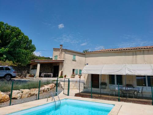 une piscine en face d'une maison et d'un bâtiment dans l'établissement Le mazet et maison Monoblet, à Monoblet