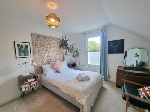 um quarto com uma cama e uma grande janela em Stylish 2-bed Flat, Quick Access to London Sights em Londres