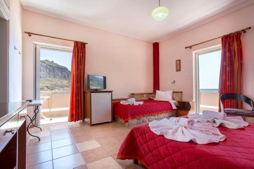 a hotel room with two beds and a balcony at Aktaion Hotel in Monemvasia