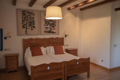 a bedroom with a large wooden bed and a lamp at OLATZEA LANDA HOTELA in Arbizu