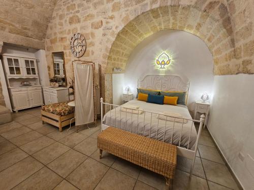 a bedroom with a bed in a room with a stone wall at Dimora Il Pumo in Corato