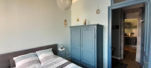 ein Schlafzimmer mit einem blauen Schrank und einem Bett in der Unterkunft Au bon air in Wimereux