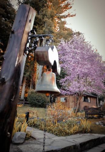 a large bell in a park with a tree at Le Bouquet Apart Hotel in San Carlos de Bariloche