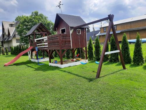a playground with a house and a slide at Apartamenty Borysek De Lux in Białka Tatrzańska
