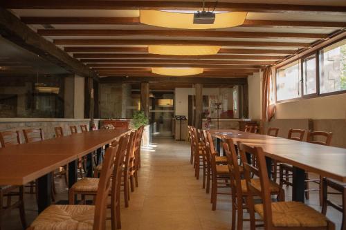 a long row of tables and chairs in a restaurant at OLATZEA LANDA HOTELA in Arbizu