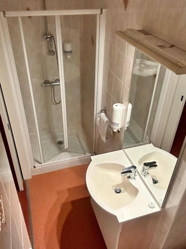 une salle de bain blanche avec un lavabo et une douche dans l'établissement Hôtel Particulier LE MAS DES MARAIS, à Machecoul