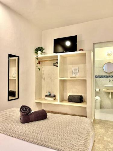 een kamer met een badkamer met een bed en een wastafel bij Casa Sabina 2 • Cosy Apt. with Wifi & TV in Holbox Island