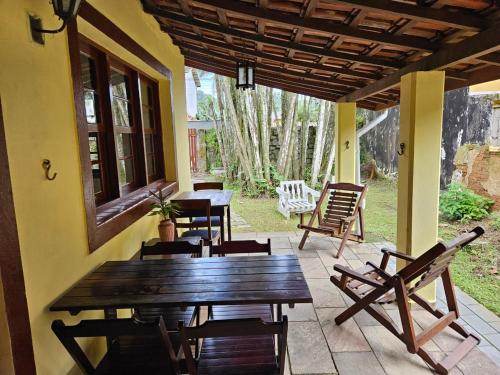 porche con mesa de madera y sillas en el patio en Pousada da Mary en Ubatuba