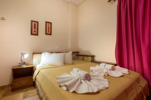 a bedroom with a bed with towels on it at Aktaion Hotel in Monemvasia