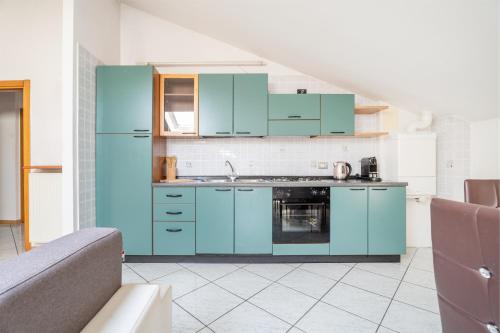 a kitchen with blue cabinets and a couch at Villa Liberty - next to Fraglia Vela Riva in Riva del Garda