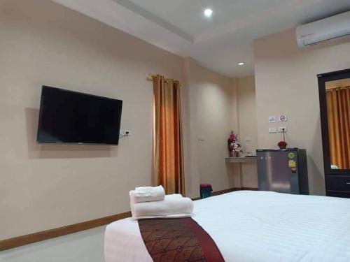a bedroom with a bed and a flat screen tv at Minton Resort มิลตั้น รีสอร์ท in Ban Kohong
