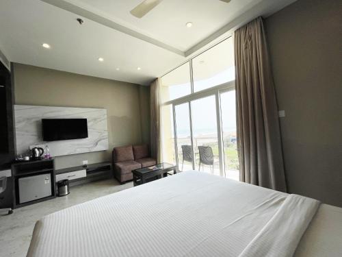 Schlafzimmer mit einem Bett, einem TV und einem Fenster in der Unterkunft Hotel TBS ! PURI all-rooms-sea-view fully-air-conditioned-hotel with-lift-and-parking-facility breakfast-included in Puri