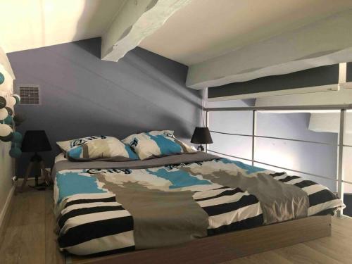 une chambre avec un grand lit aux murs bleus dans l'établissement Le chant des Cigales STUDIO Duplex climatisé près des plages, à Sausset-les-Pins