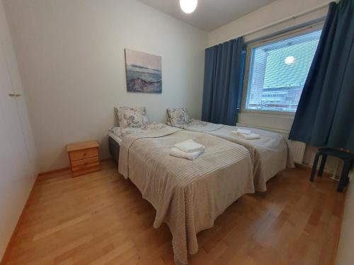 a bedroom with a bed and a window with blue curtains at Rovaniemi Ruokasenkatu apt - Wi-Fi - Sauna - Free Parking in Rovaniemi