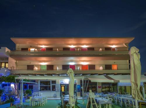 a restaurant with tables and chairs at night at Aktaion Hotel in Monemvasia