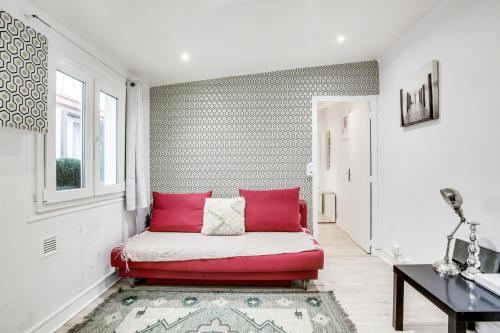 ein Wohnzimmer mit einem roten Sofa und einem Fenster in der Unterkunft 9 min de l'hippodrome avec terrasse privée in Suresnes