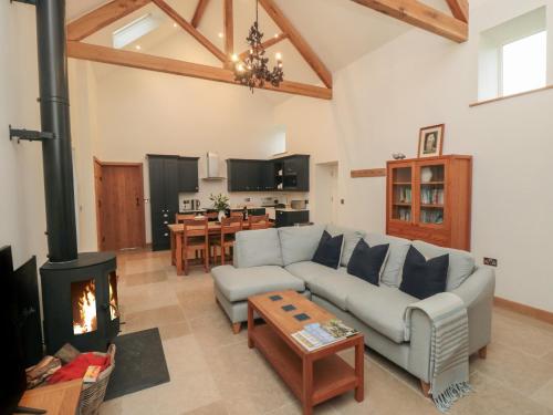 a living room with a couch and a fireplace at Owl Barn in Whitby