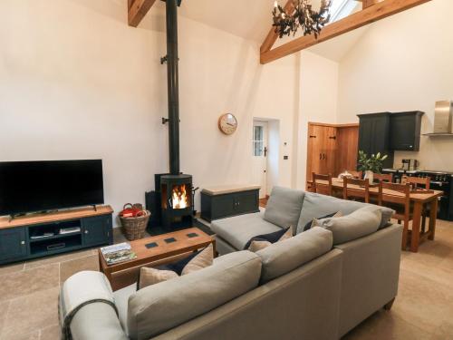 a living room with a couch and a fireplace at Owl Barn in Whitby