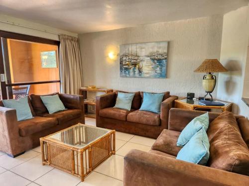 ein Wohnzimmer mit 2 Sofas und einem Tisch in der Unterkunft San Lameer 3125 by Top Destinations Rentals in Southbroom
