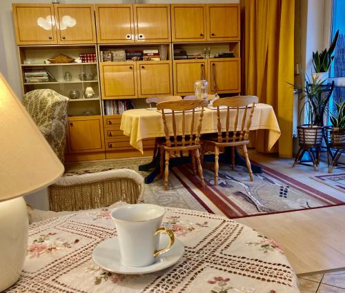 a dining room with a table and chairs and a coffee cup at Apartament 2 sypialnie, 2 łazienki, taras, parking in Warsaw