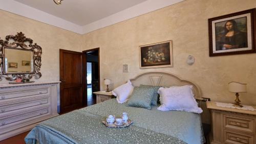 una camera con letto, cassettiera e specchio di Angolino a Radda in Chianti