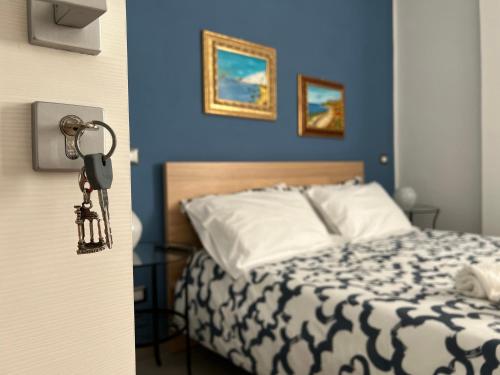 ein Schlafzimmer mit einem Bett mit blauen Wänden und einem Haufen Schlüssel in der Unterkunft Liu' al viale in Agrigento